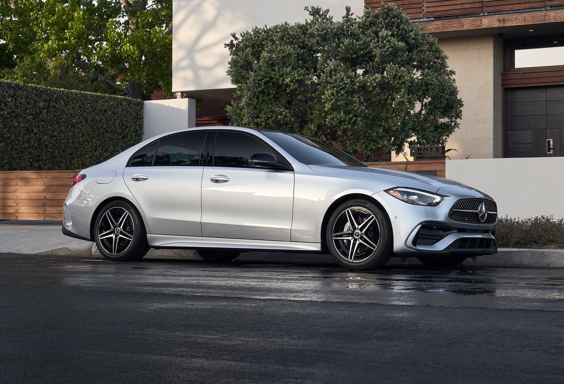 A white 2026 Mercedes-Benz C-Class parked in front of a house